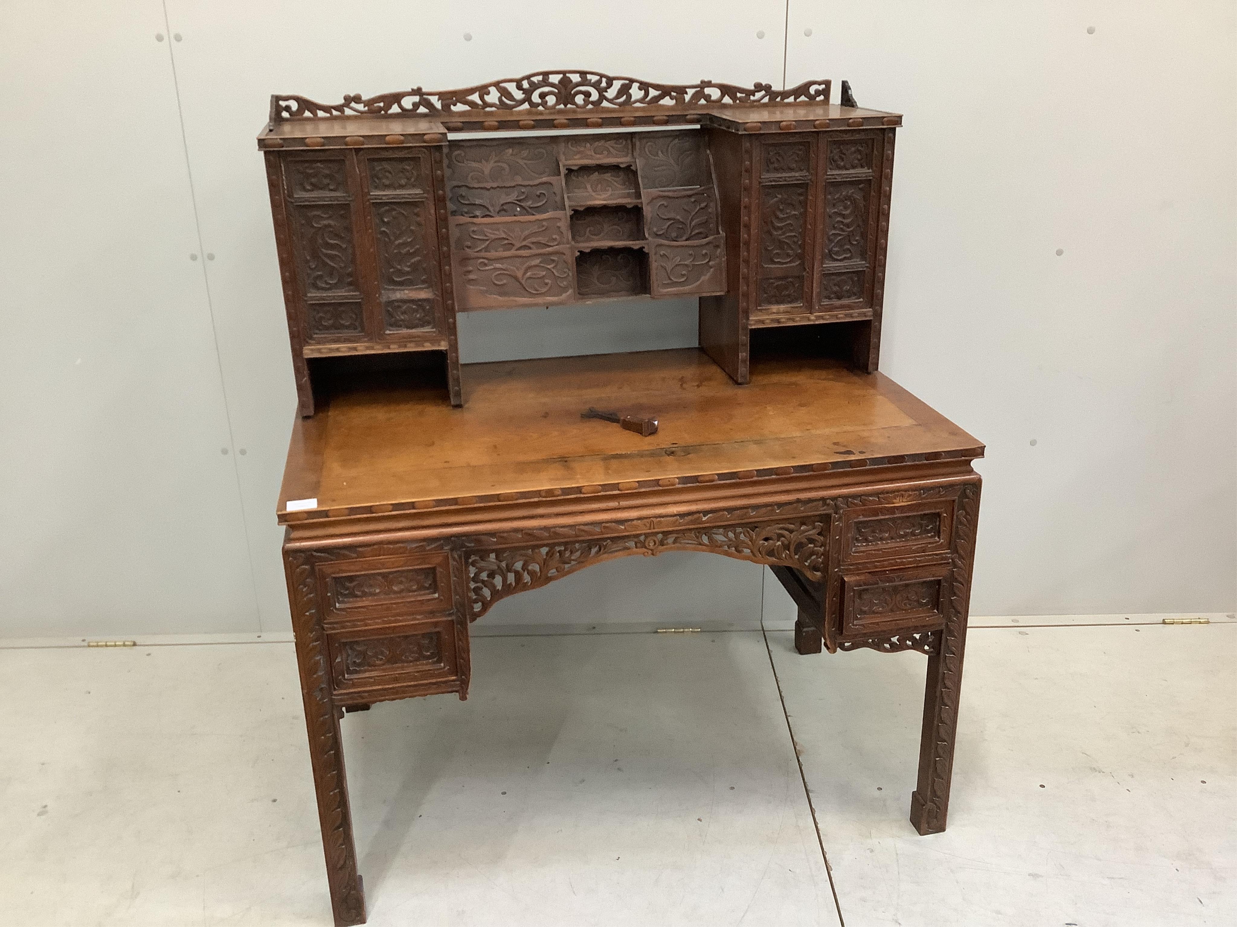 A late 19th century Chinese export carved hardwood kneehole writing desk, width 107cm, depth 66cm, height 120cm